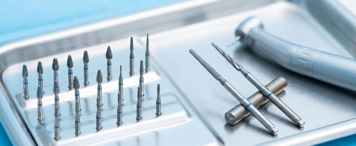 330 pear-shaped carbide burs and Zekrya surgical burs displayed on a stainless steel dental tray.