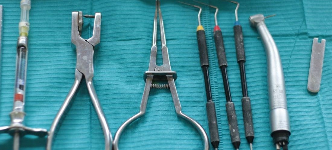 Dental equipment & instruments neatly arranged on teal cloth for dental procedures